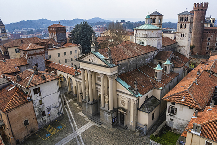 Duomo di Ivrea con facciata neoclassica e colonne, tra i tetti rossi del centro storico e le torri medievali