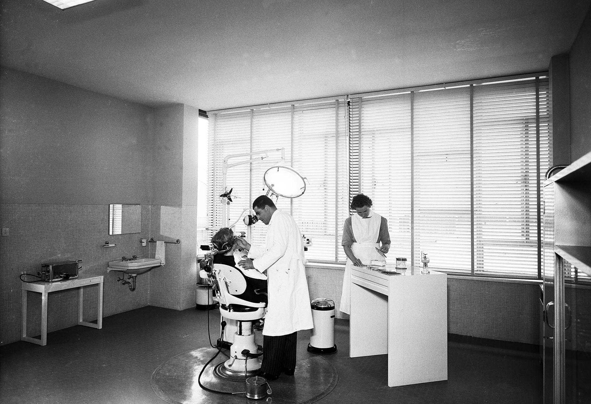 Ambulatorio aziendale Officine Olivetti a Ivrea: medico e infermiera al lavoro con poltrona odontoiatrica