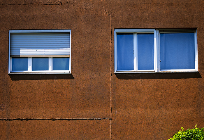 Due finestre rettangolari su facciata in intonaco ruggine, dettaglio architettura urbana di Ivrea