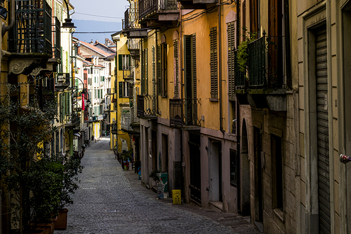 Vicoli acciottolati del centro storico medievale di Ivrea con facciate colorate e balconi che richiamano il carattere urbano